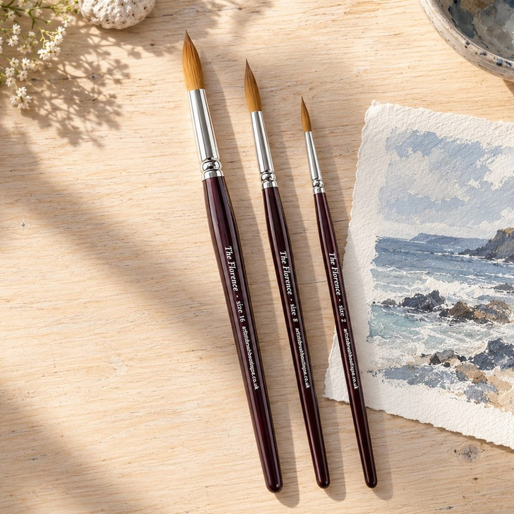 Three Florence brushes on the table beside a seascape painting